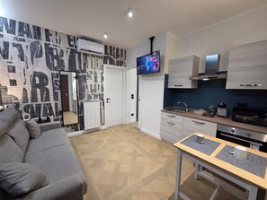 Suite superior, 2 habitaciones, regadera para personas con discapacidad, microondas | Área de sala de estar | Televisión y impresora 
