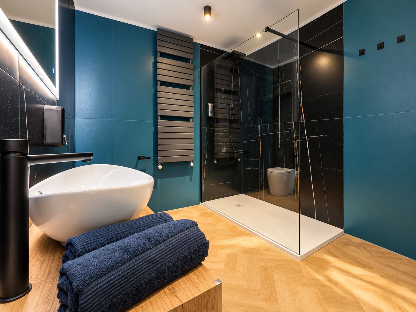 A modern bathroom with a large white sink, a glass shower enclosure, and a wooden vanity.