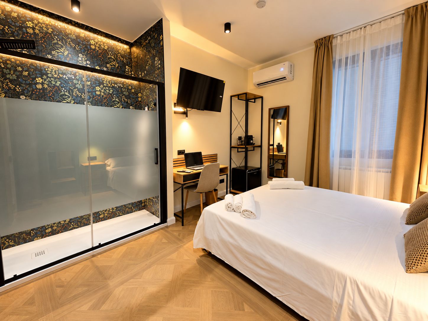 A hotel room with a bed, desk, and a TV.