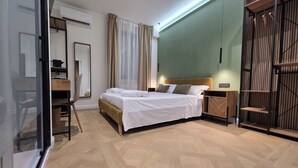 A modern hotel room with a large bed, a desk, and a wardrobe. - Centro & Mare - Rooms & Suites (Termoli)