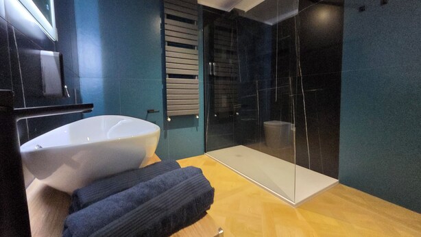 A modern bathroom with a large white sink, a glass shower enclosure, and a wooden vanity. - Centro & Mare - Rooms & Suites (Termoli)