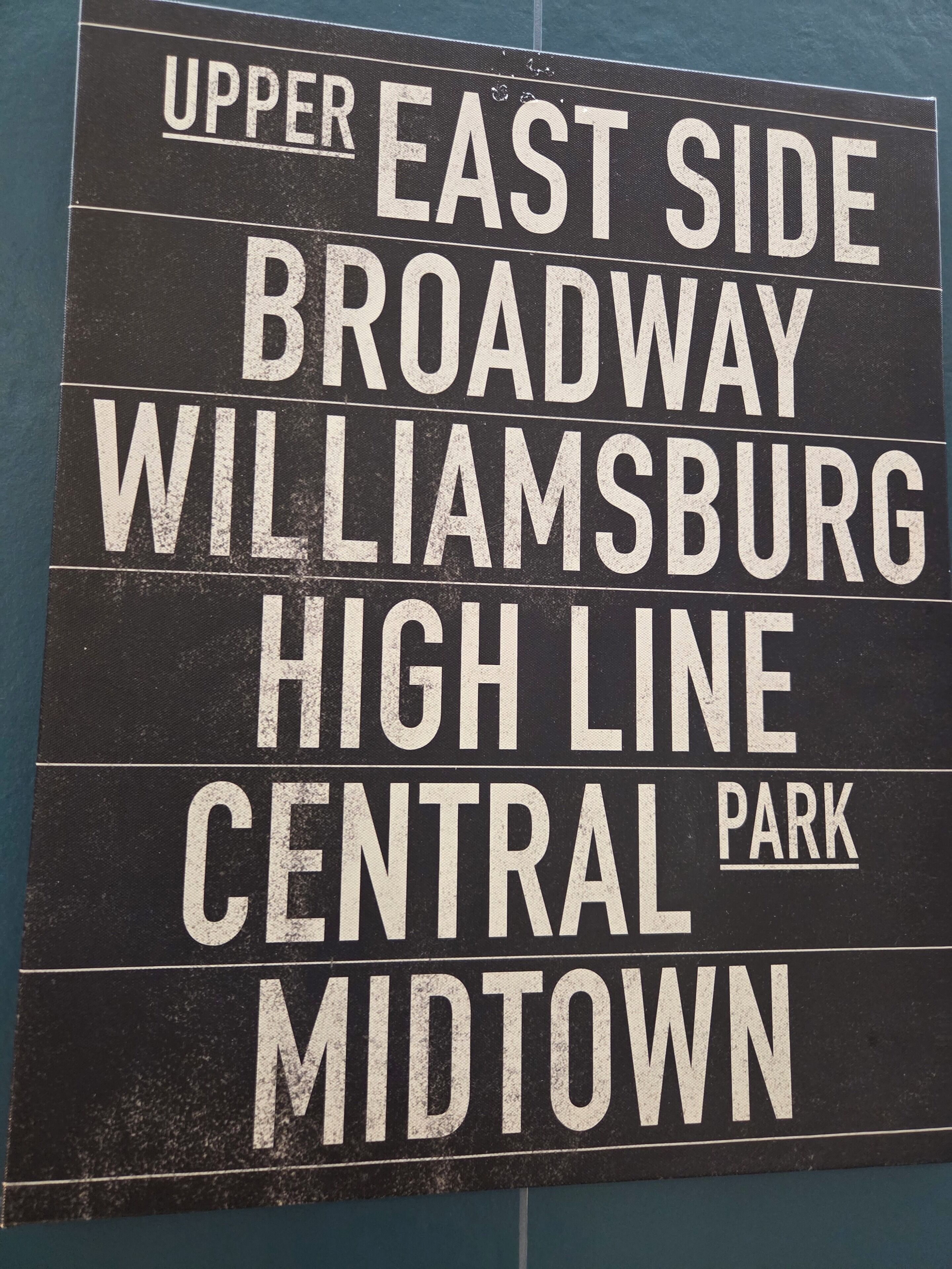 Un panneau indiquant les lieux suivants : « Upper East Side, Broadway, Williamsburg, High Line, Central Park, Midtown ».