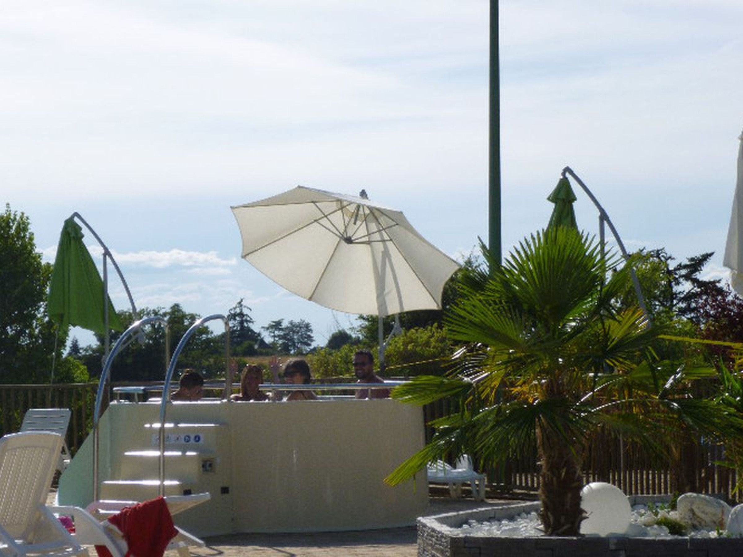 A pool area with lounge chairs, a bar, and umbrellas.