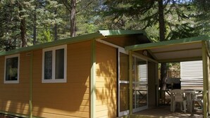 A small, single-story cabin with a covered porch and a patio area.