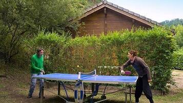 Zwei Personen spielen Tischtennis draußen an einem mobilen Tisch.