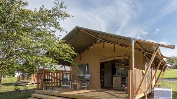 A wooden deck with a covered patio area, a small outdoor kitchen, and a wooden fence. - Spacious chalet for 8 people - Pond view - Terrace (Naucelle)