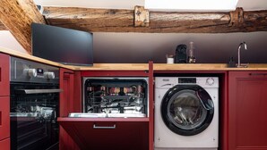 A compact kitchen with a built-in dishwasher, oven, and washing machine. - La Dolce Suite | Porta Romana Metro (Milano)