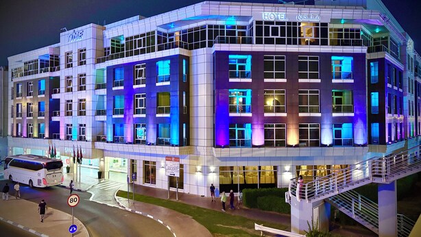 A modern hotel with multiple floors, large windows, and a prominent entrance. - Time Grand Plaza (Dubai)