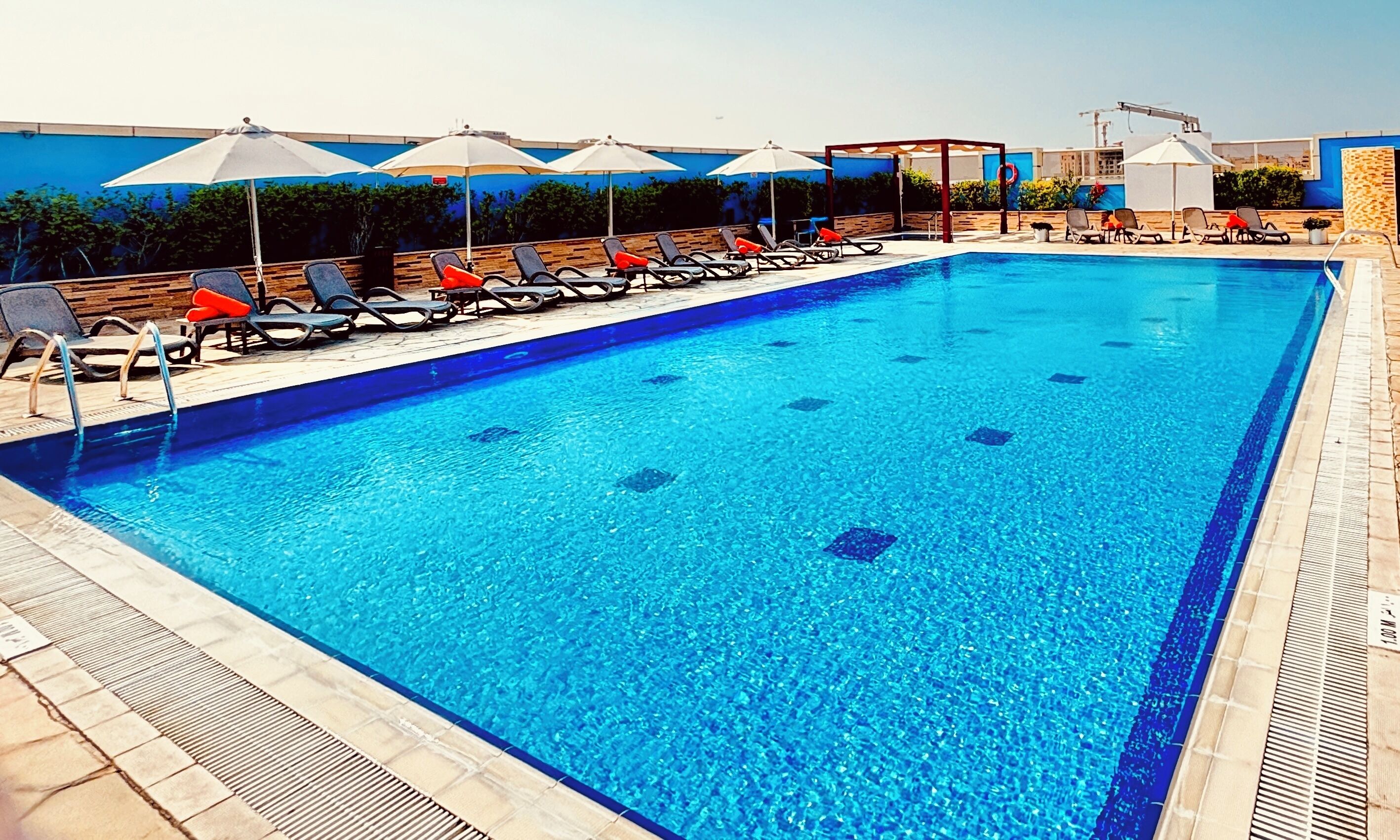 Una piscina cubierta, sombrillas, tumbonas