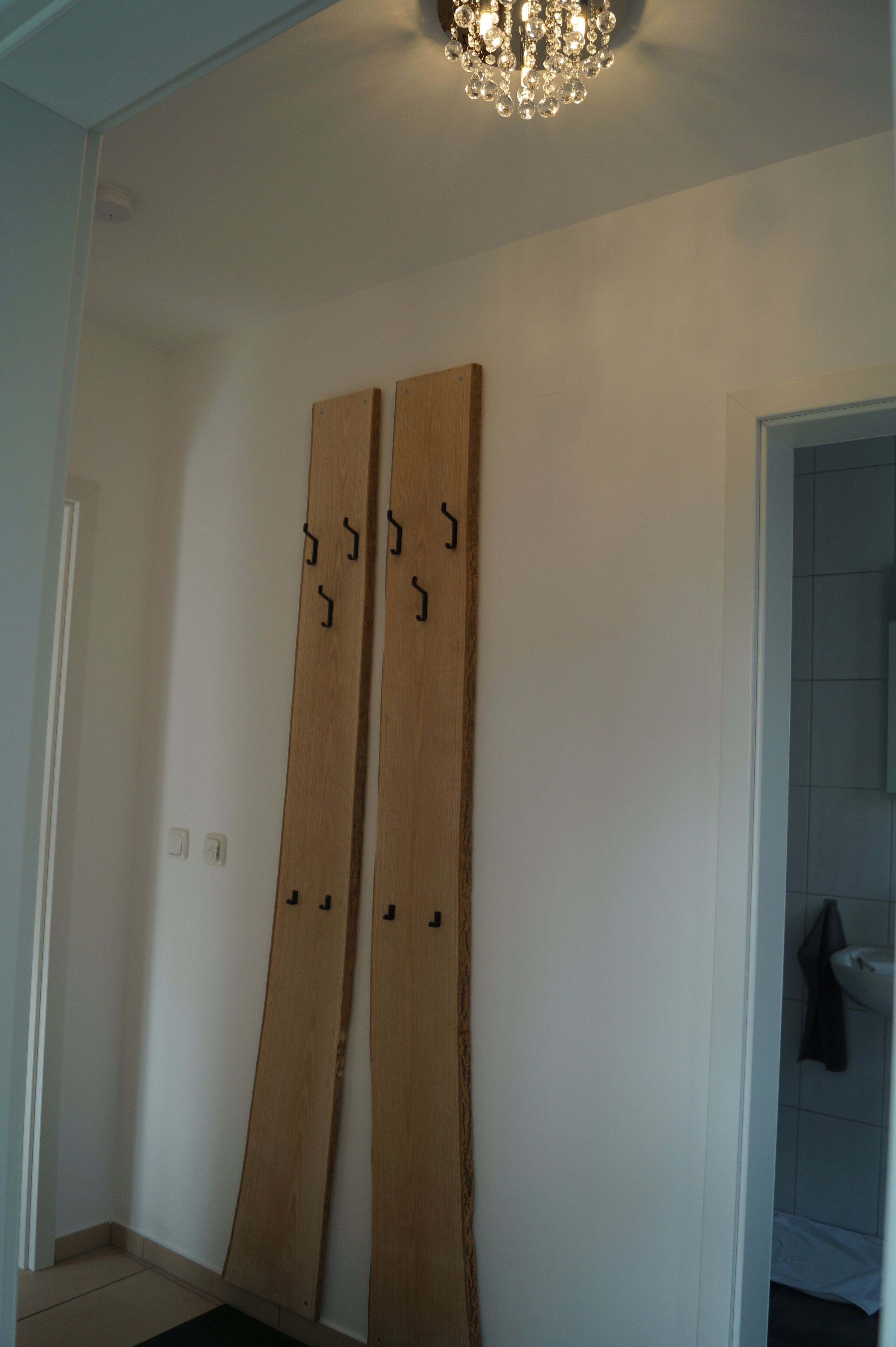 A room with a wooden door and a chandelier.