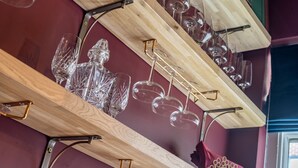 A wooden wine rack with multiple glasses and a crystal decanter. - Friargate House -  a premium stay that sleeps 9 guests  in 4 bedrooms (York)