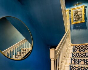 Een trap met witte balustrades en blauwe, patroonrijke treden.