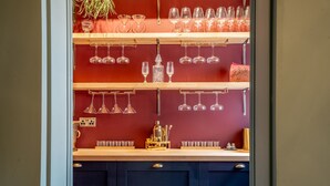 A bar area with shelves holding wine glasses and a coffee machine. - Friargate House -  a premium stay that sleeps 9 guests  in 4 bedrooms (York)