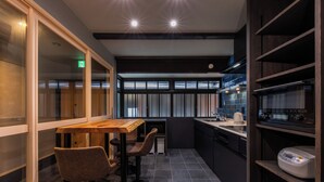 Una cocina moderna con armarios oscuros, una barra de madera y una máquina de café.