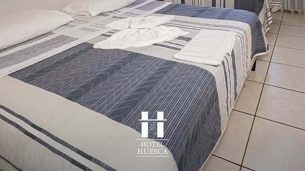 A hotel room with two beds, a large window with curtains, and a tiled floor. - Hotel Palace Huesca (Presidente Prudente)