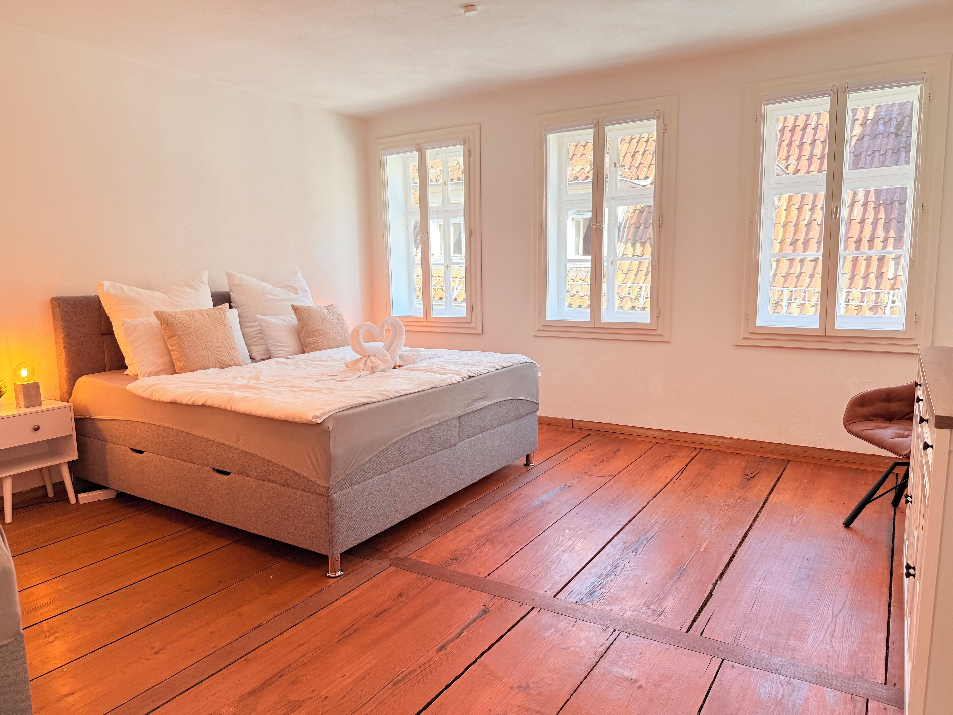 A bedroom with a bed, a nightstand, and a chair.