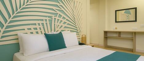 Habitación de hotel con una cama, una decoración grande en la pared, una mesita de noche y un espejo.