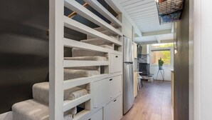 A modern kitchen with a built-in refrigerator and a dining area with a small table and chairs. - Modern Condo with Vail Mountain Views (Vail)