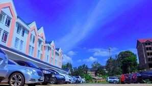 A row of modern buildings with a clear blue sky and a bird flying overhead. - Semara Hotels Machakos (Machakos)