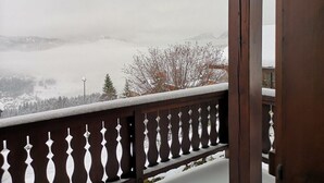 A wooden balcony with a snow-covered railing overlooking a mountainous landscape. - Chalet "Les Mouflons" - Le Clos - Sleeps 8, 5 minutes walk from the ski slopes (Crest-Voland)