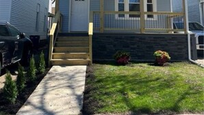 A two-story house with a front porch, a visible chimney, and a small front yard with a pathway leading to the door. - Newly renovated luxurious and private, 3-bedroom 2 bath West Side Oasis! (Buffalo)