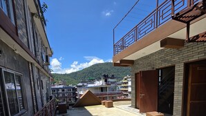 Un patio con piso de concreto, una rampa de madera y vistas a la montaña.