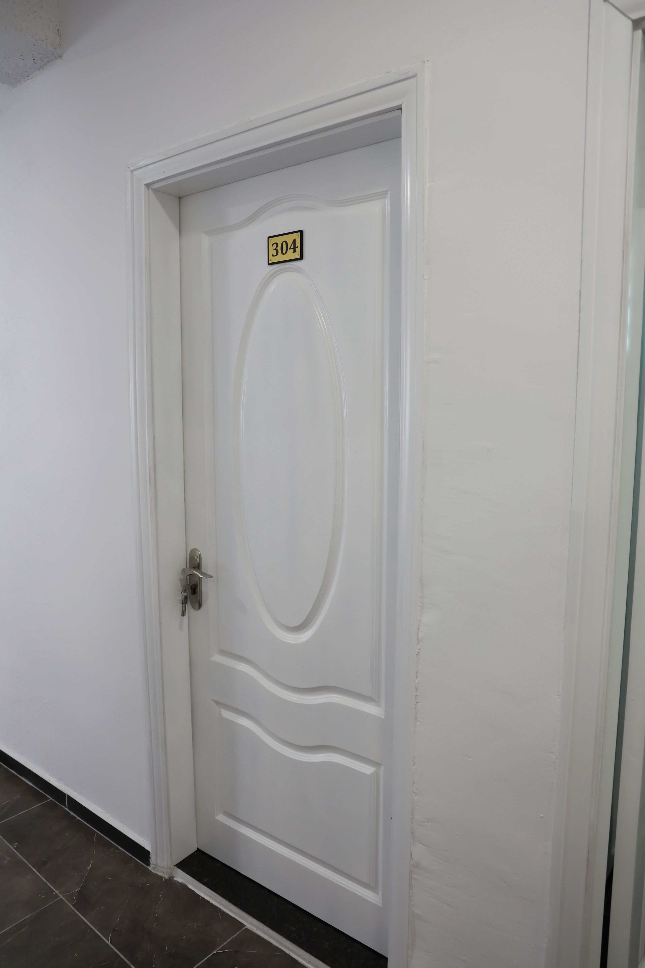 A white door with a number plate indicating room 304.