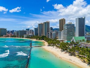 Un paisaje urbano costero con edificios altos, una playa y un muelle.