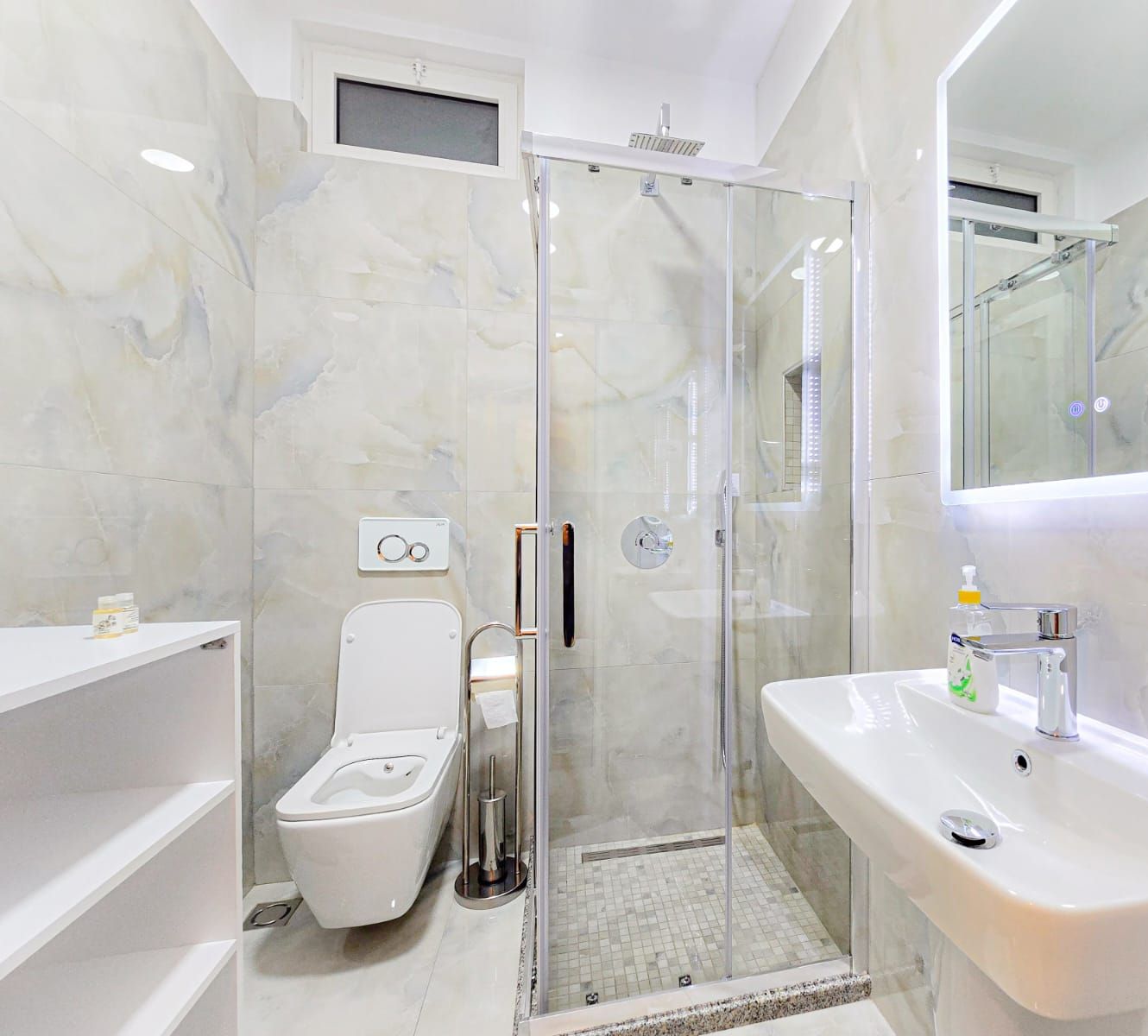 Une salle de bain moderne avec une douche à parois de verre, des toilettes et un lavabo avec un miroir.