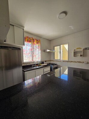 Fridge, microwave, oven, stovetop - Family house - Suites with air conditioning, swimming pool and barbecue, 250m from Sapê beach. (Praia do Sape Ubatuba)