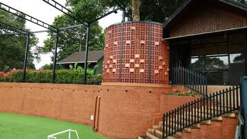 A building with a brick exterior, a cylindrical structure with multiple windows, and a staircase leading to a covered area.