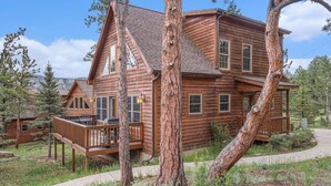 A log cabin with a deck, surrounded by trees. - Wildlife, shared hot tub, fireplace, deck, BBQ! (Estes Park)