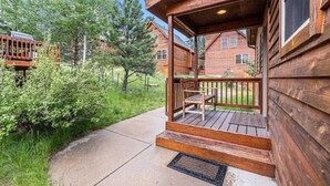 A wooden cabin with a porch, a bench, and a grill. - Upstairs AC! Fireplace, deck, BBQ, shared hot tub (Estes Park)