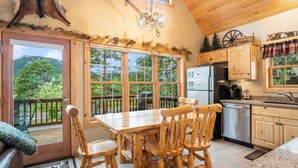 Un rustico chalet con zona pranzo, cucina e un balcone con vista panoramica.