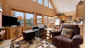 A spacious living area with a large window, a television, a fireplace, and a dining area. - Panoramic RMNP Views. K beds, deck, fireplace, BBQ (Estes Park)