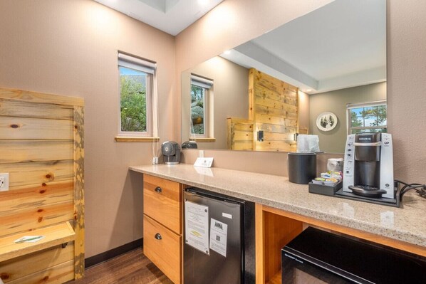 A modern kitchen with a built-in dishwasher, a coffee maker, and wooden cabinetry.