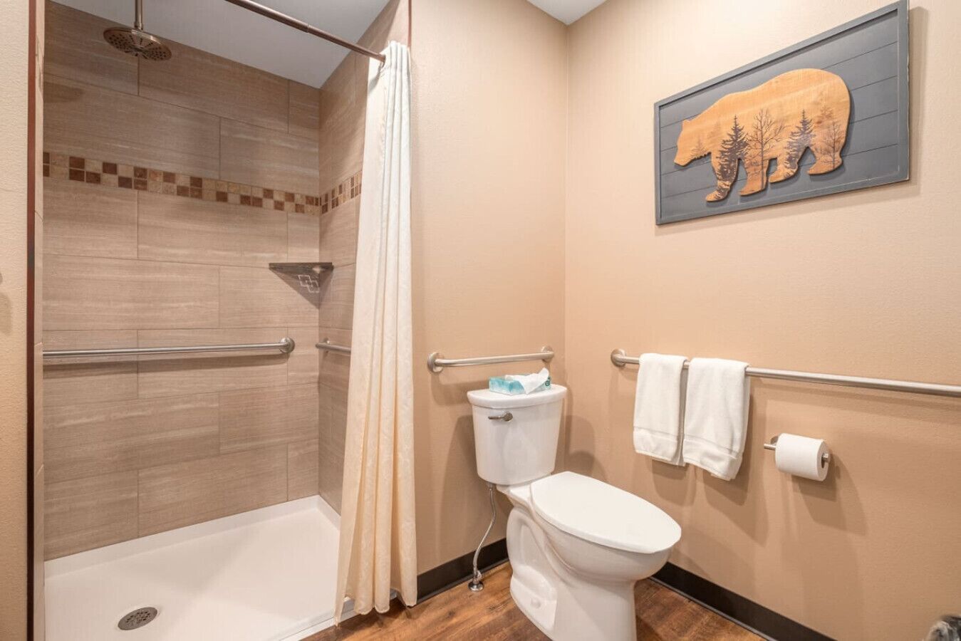 A bathroom with a shower, toilet, and a towel rack.