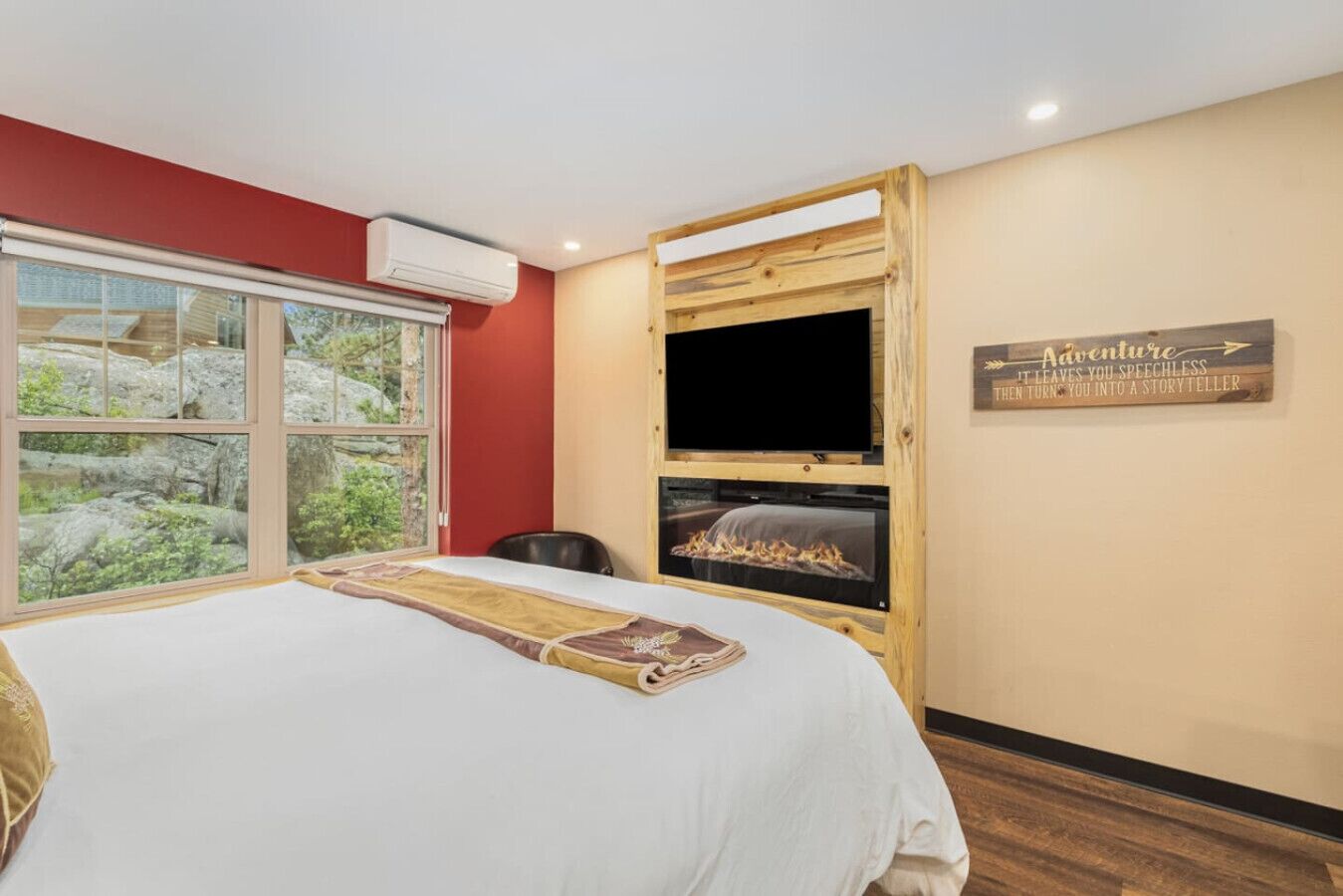A bedroom with a large bed, a TV, and a fireplace.