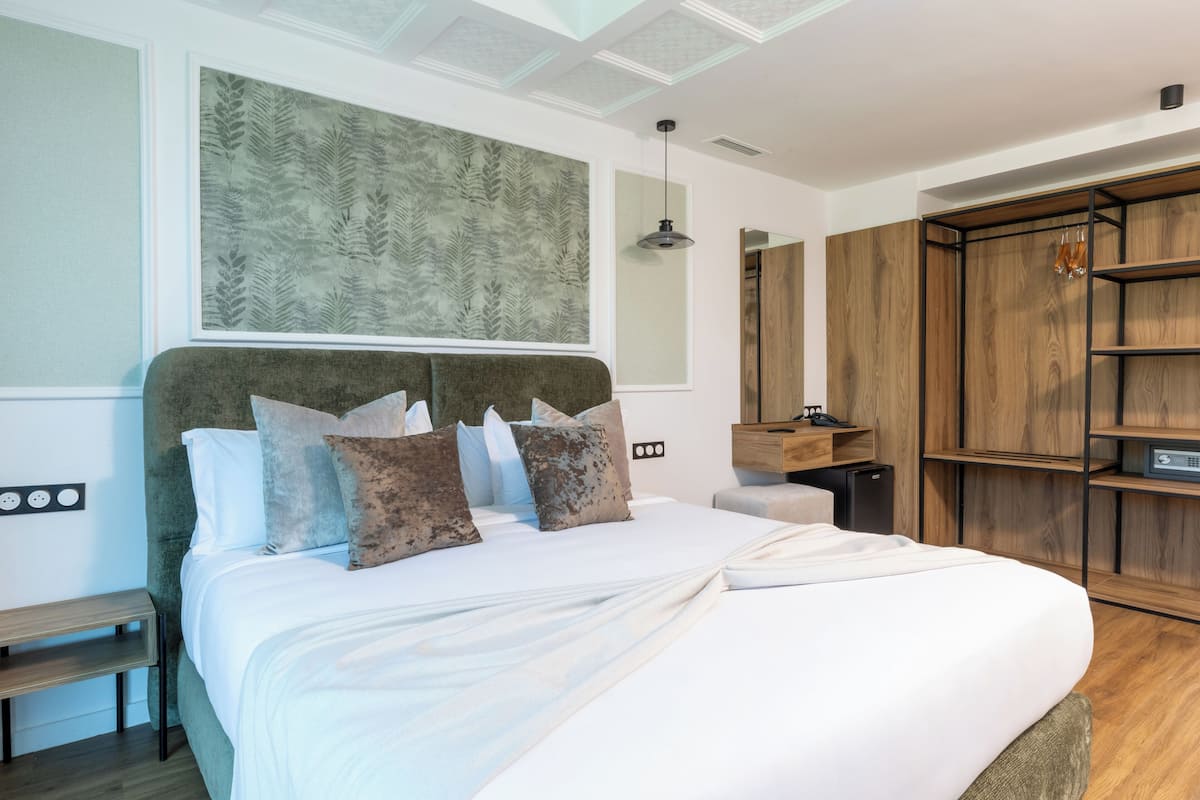 Un dormitorio moderno con una cama grande, un armario de madera y una obra de arte en la pared.