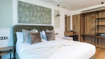 A modern bedroom with a large bed, a wooden wardrobe, and a wall-mounted artwork.