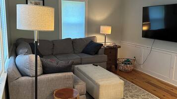 TV connectée, cheminée, table de tennis de table, livres