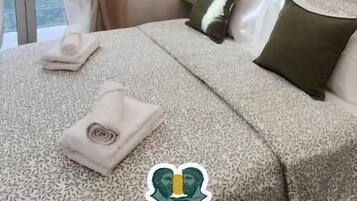 Un dormitorio moderno con una cama grande, vistas a la ciudad y el logo de Reggiada House B&B.