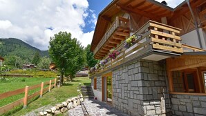 Un bâtiment en pierre doté d’un balcon en bois et de jardinières.