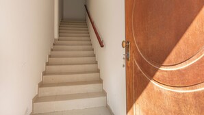 Un escalier menant à une porte dotée d’une poignée de porte en laiton.