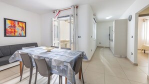 Un salon moderne avec une table à manger, un canapé gris et un tableau accroché au mur.