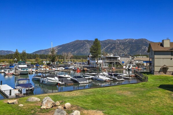 A marina with boats docked, a grassy area, and a building with a staircase.