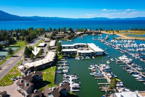 A marina with boats docked, surrounded by residential buildings and a clear view of the lake.