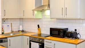 A modern kitchen with white cabinets, a stainless steel range hood, a microwave, and a toaster. - Pass the Keys | Llandaff - Modern, Bright & Central w/Parking (Cardiff)