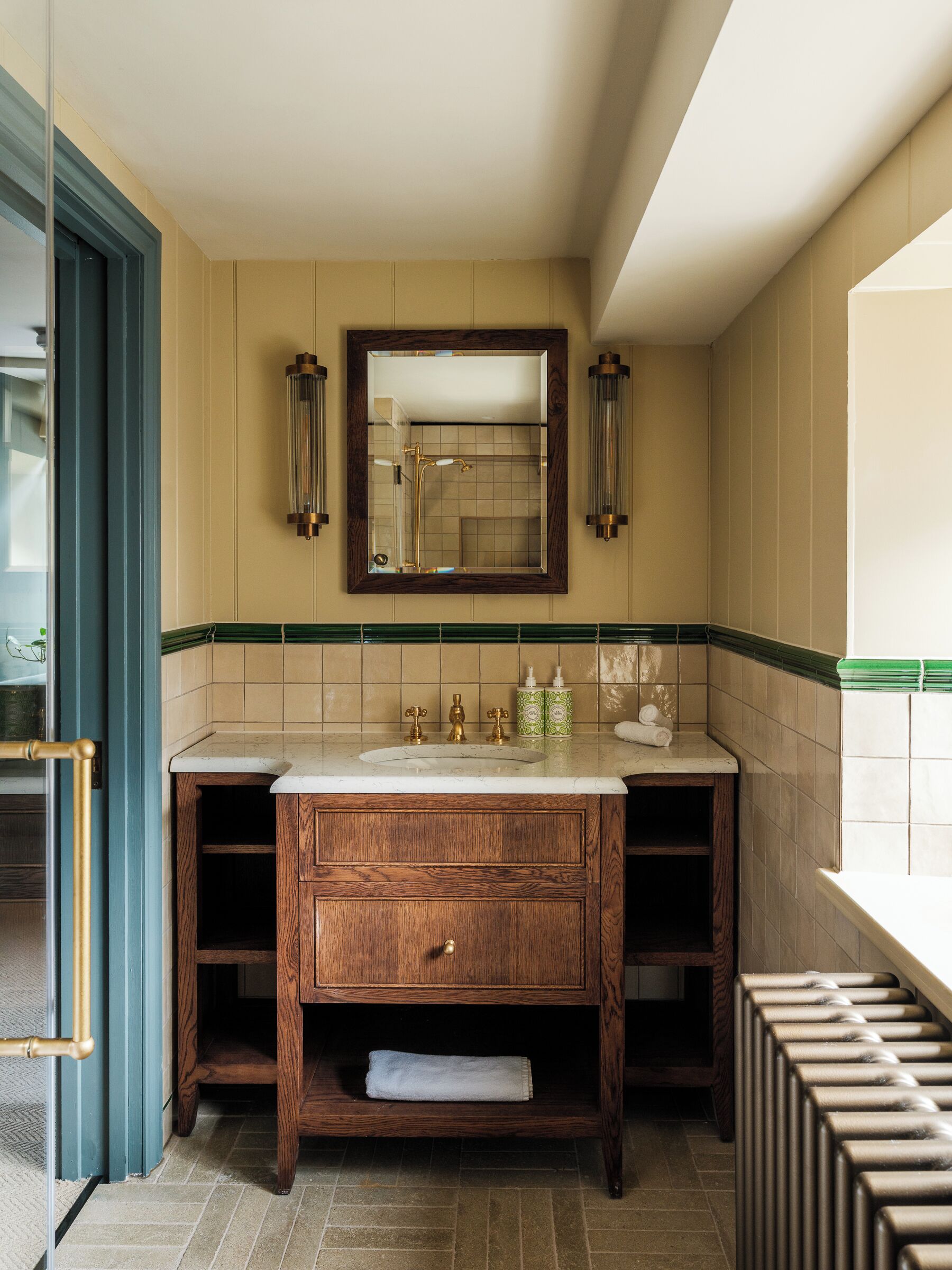 A bathroom with a wooden vanity, a large mirror, and a towel rack.