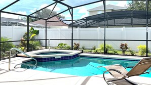 A backyard pool area with a hot tub, lounge chairs, and a covered patio. - 4BR Private Pool & Spa | Game Room | 35 Min to Disney (Davenport)